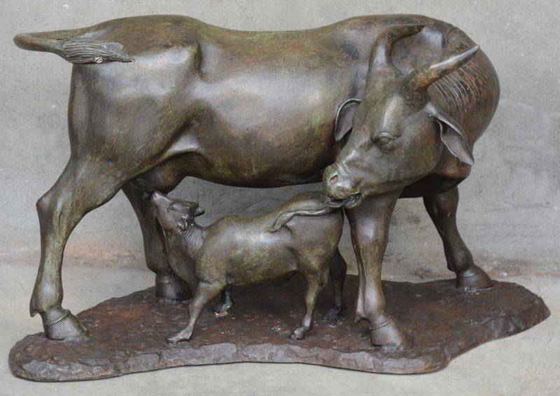 Een bronzen beeld van een waterbuffel met een zogend kalf.