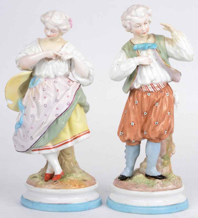 Paar polychrome porseleinen beeldjes van een jongen en een meisje. Onderaan gemerkt met gekruiste zwaarden. Lichte schade aan de hoed van het meisje.