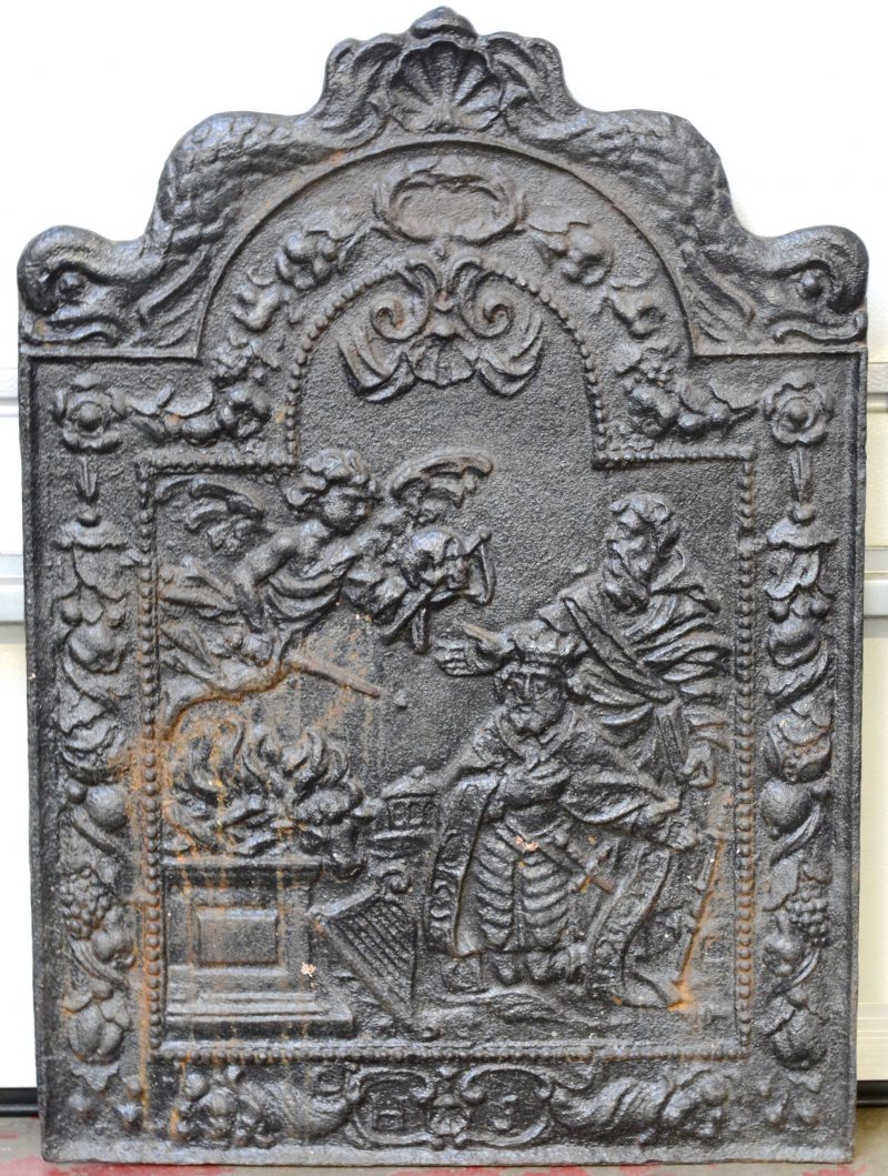 Een gietijzeren haardplaat met een Bijbelse scène in reliëf.
