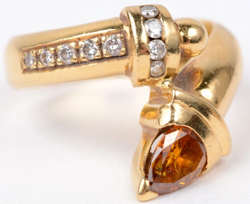 Een 18 karaats geel gouden ring bezet met een fancy diamant van ± 0,50 ct. en briljanten met een gezamenlijk gewicht van ± 0,15 ct.