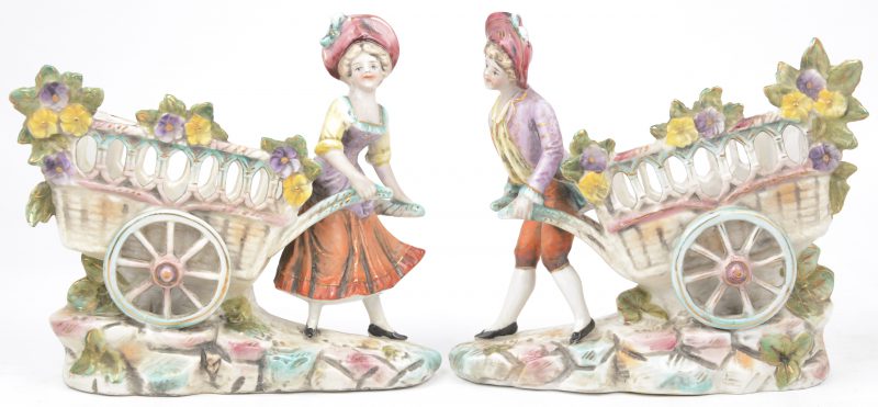 Twee sierjardinières van meerkleurig porselein in de vorm van een man en een vrouw met kar.