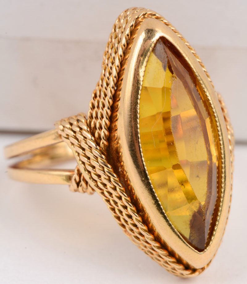 Een 18 karaats geel gouden ring versierd met filigraan en bezet met een barnsteen.