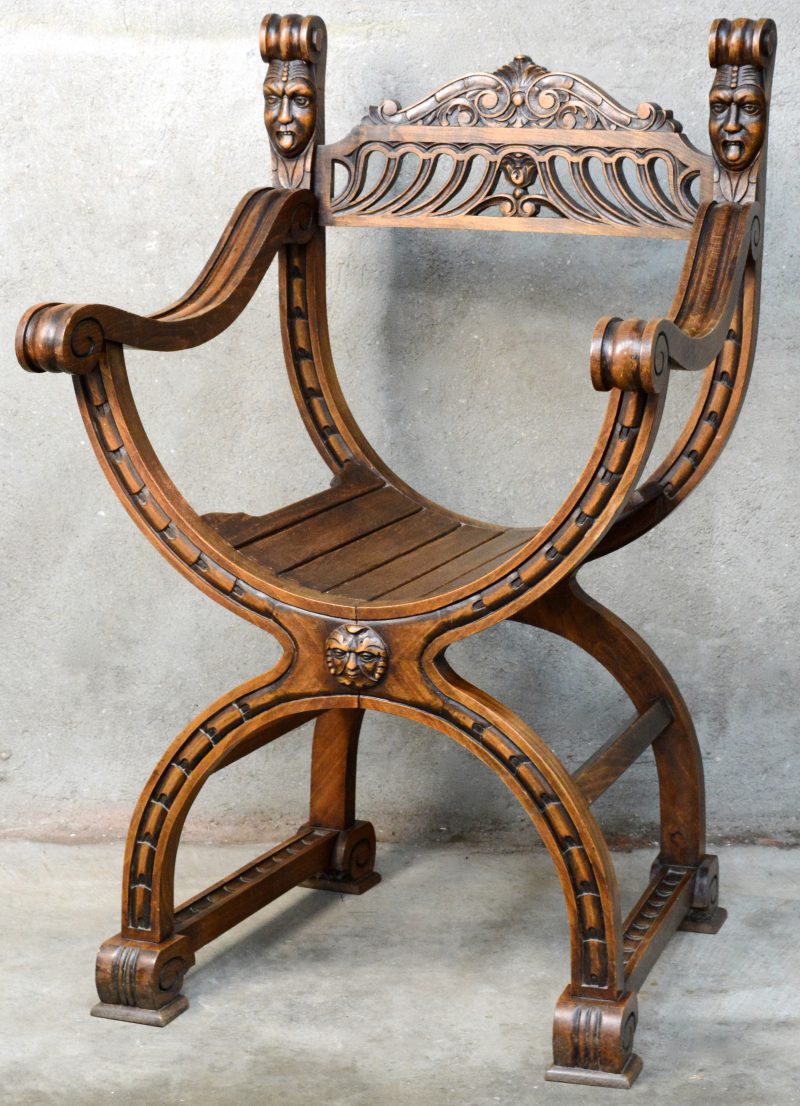 Een eikenhouten dagobertstoel met opengewerkte rug en met twee hoofdjes.