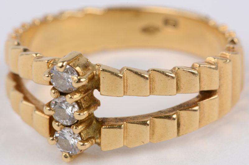 Een 18 karaats geel gouden ring bezet met briljanten met een gezamenlijk gewicht van ± 0,15 ct.