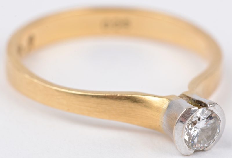 Een 18 karaats wit en geel gouden ring bezet met een solitair van ± 0,25 ct.