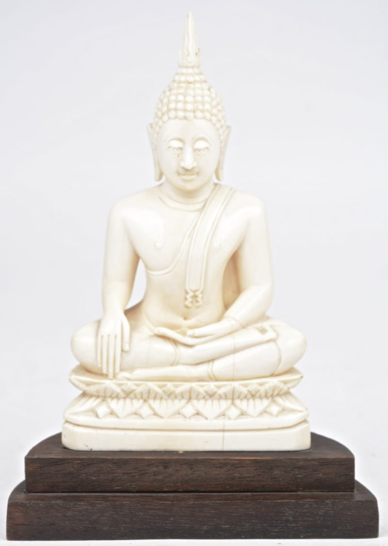 “Zittende Boeddha.” Ivoren beeldje op sokkel.