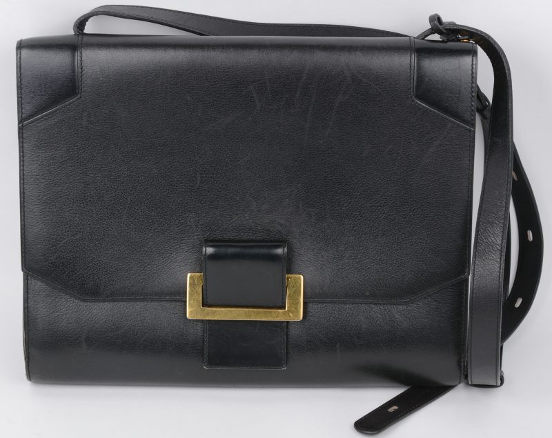 Een zwarte vintage handtas met stoffen hoes.