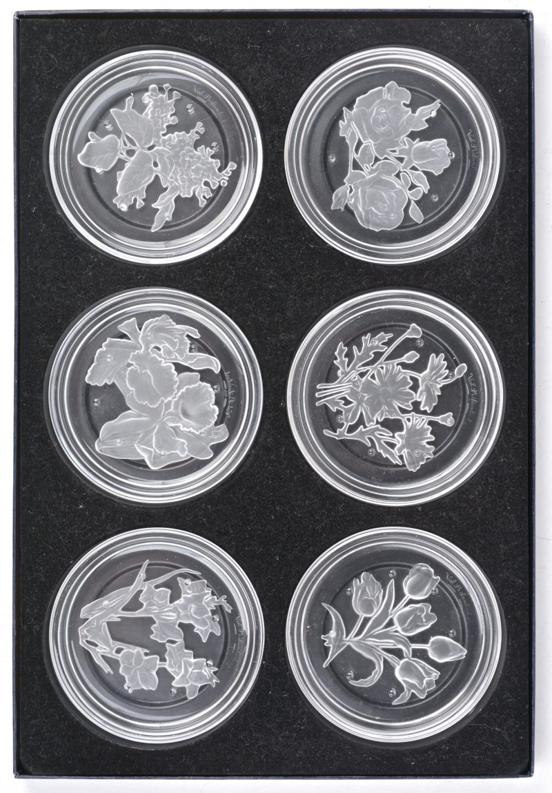 Een reeks van zes onderleggers van geslepen kleurloos kristal met gesatineerde bloemendecors. In origineel etui.