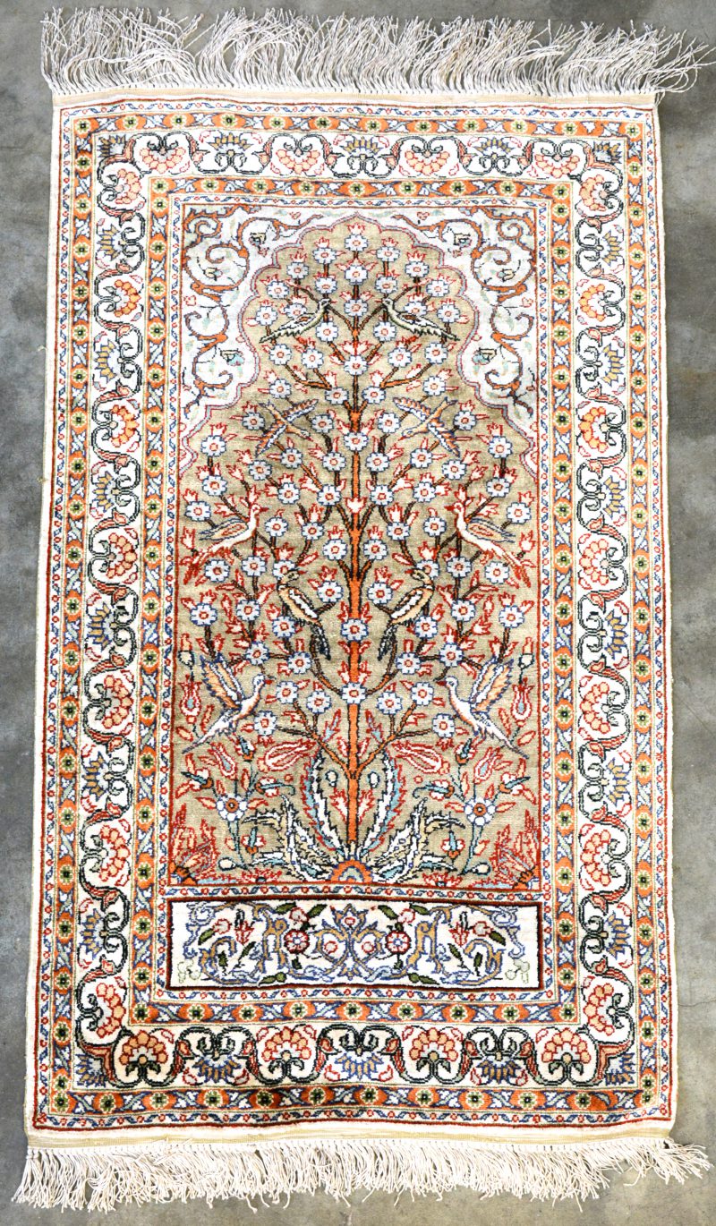 Een zijden tapijtje gedecoreerd met levensboom.