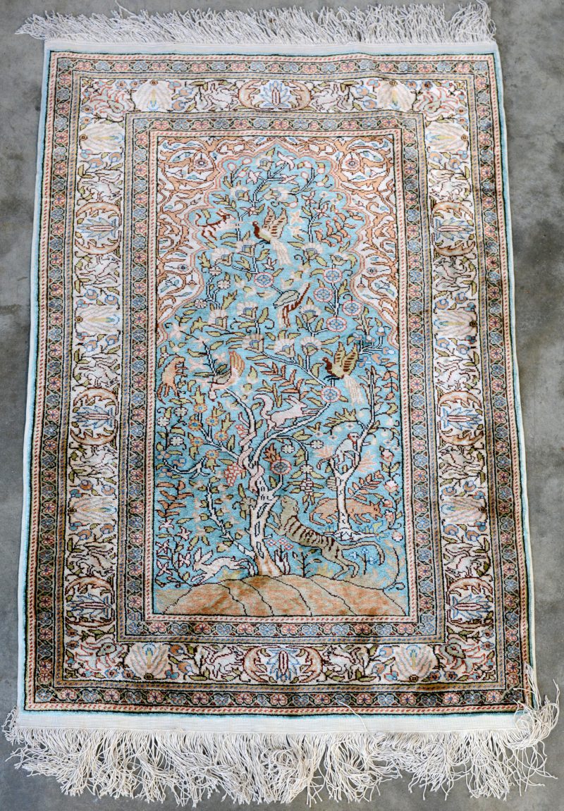 Een zijden tapijtje gedecoreerd met levensboom.
