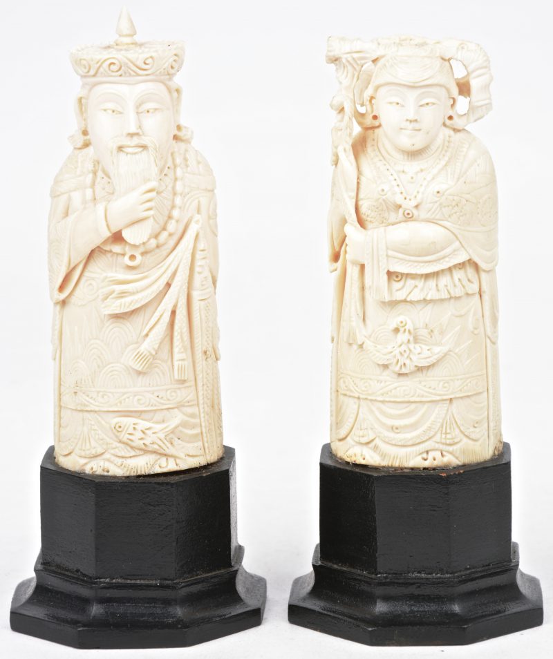 Een keizerskoppel uit ivoor. Twee beeldjes met houten sokkel.