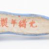 Tien eetstokjesleggers van meerkleurig Chinees porselein in de vorm van liggende personages. In twee etuis.