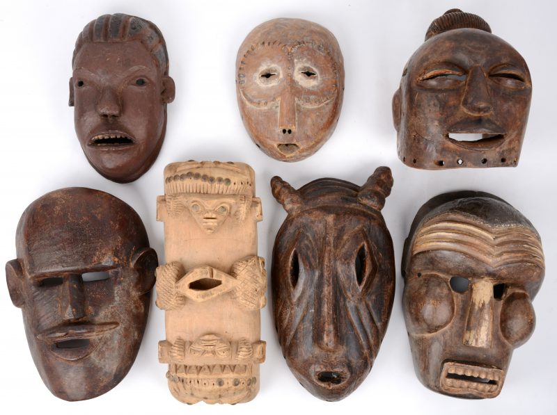 Een reeks van zeven Afrikaanse houten maskers.