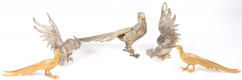 Een lot van vijf metalen siervoorwerpen, bestaande uit twee vechtende hanen, twee goudgepatineerde fazanten en een fazant.