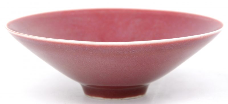 Een waterkommetje van Chinees porselein met rood glazuur. Onderaan gemerkt.