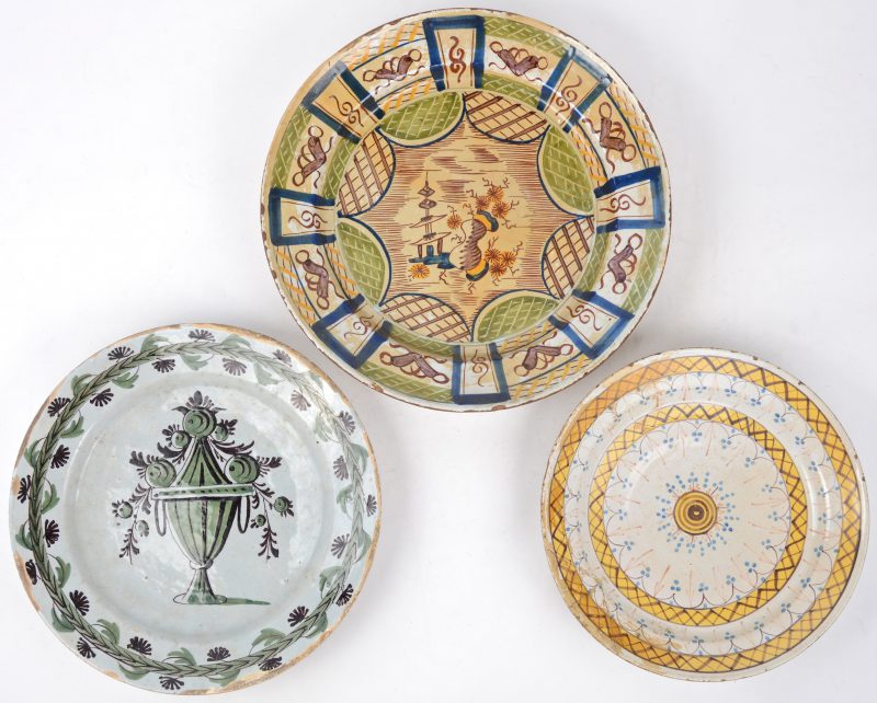 Drie verschillende borden van meerkleurig aardewerk. XVIIIe eeuw. restauraties en randschade.