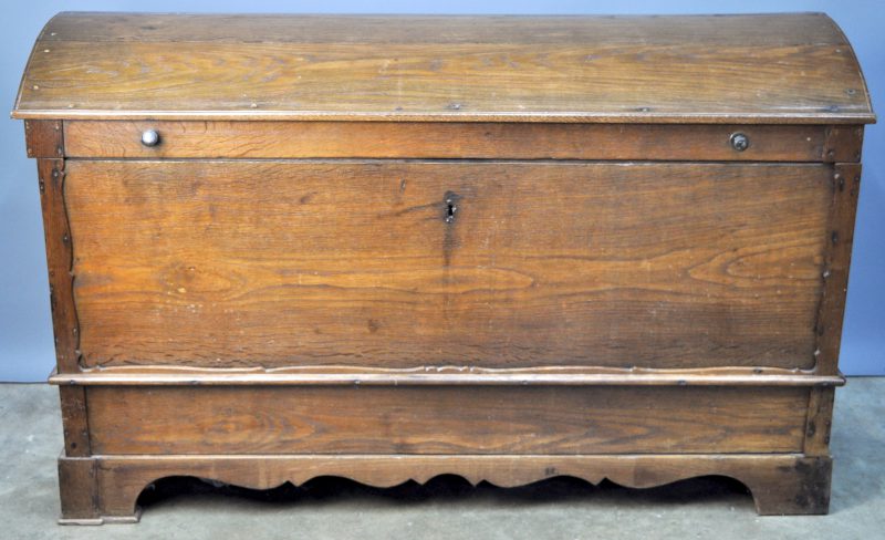 Een grote houten koffer met gegalbeerd deksel.