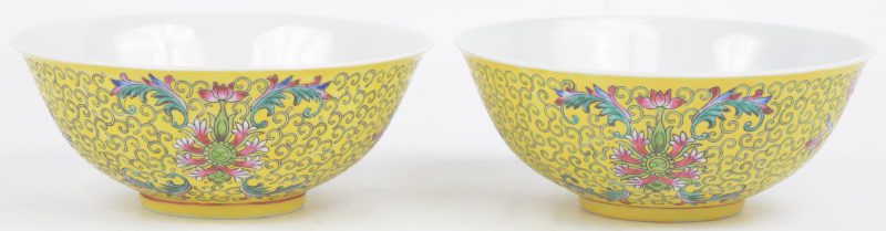 Twee kommen van Chinees porselein met een bloemendecor op gele fond. Onderaan gemerkt.