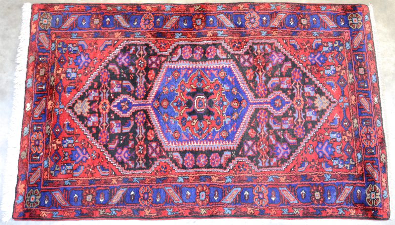 Een handgeknoopt Oosters wollen karpet met geometrisch motief.