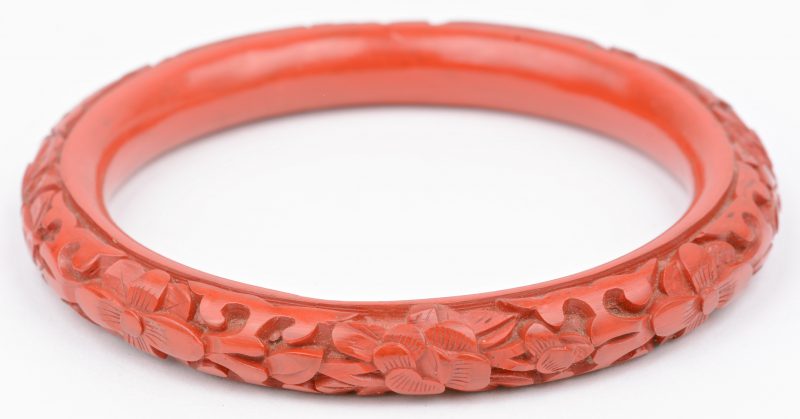 Een rode Chinese armband van gelakt hout.