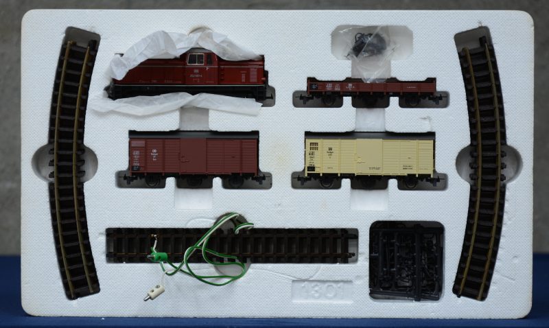 Een startersset, bestaande uit een diesellocomotief met vier verschillende goederenwagons van de Duitse spoorwegen en rails. Spoortype HO-m. In originele doos.