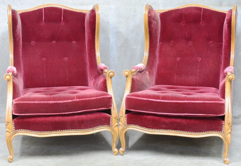 Twee wing-back chairs, bekleed met robijnrood fluweel.