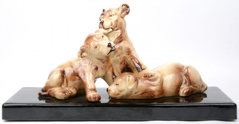 “Drie puppy’s”. Een art deco groep van geglazuurd aardewerk.