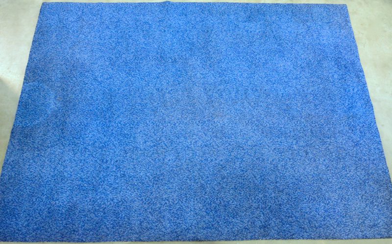 Een machinaal blauw wollen tapijt.