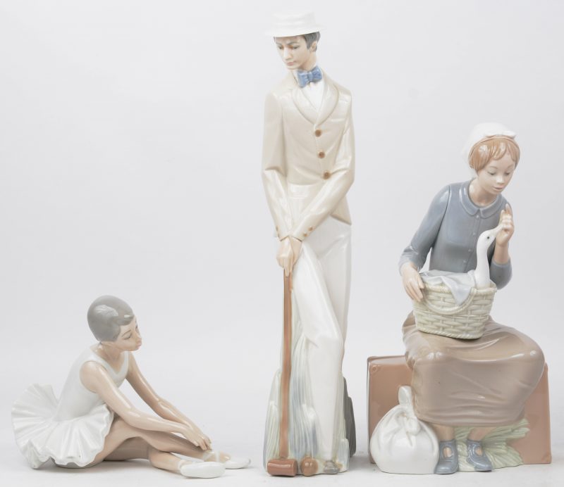 Een lot van drie polychroom porseleinen beeldjes. Meisje met eend, een ballerina en een croquet speler.