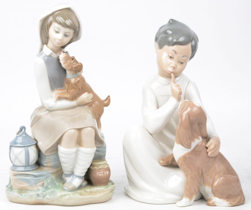 Twee beeldjes van polychroom porselein, respectievelijk een meisje en jongen met hond.