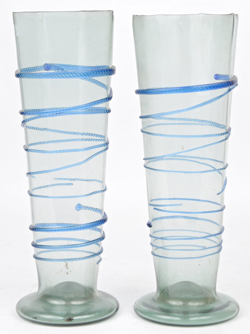 Een paar antieke achthoekige glazen vazen met een blauwe koordversiering.