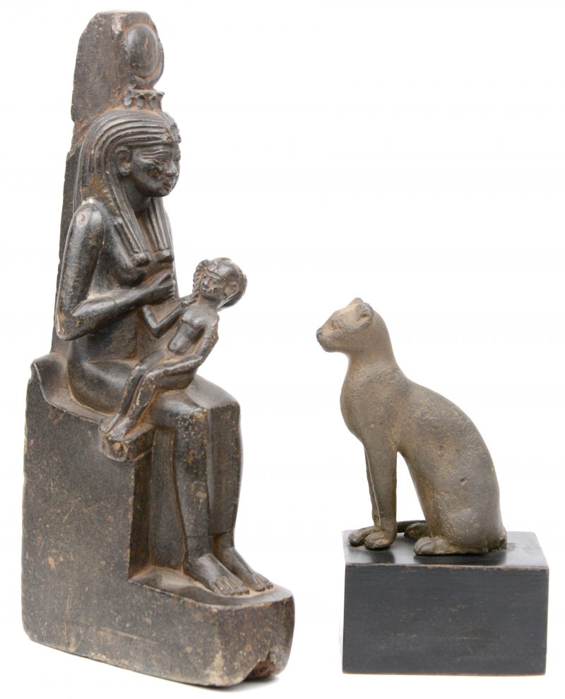 Een stenen beeltenis van Isis en een zittende kat van brons. Egypte.