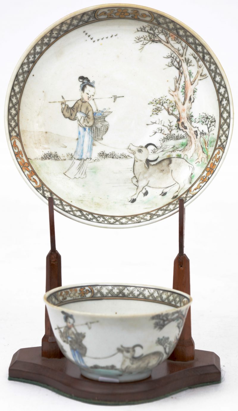 Een theekommetje met bordje met een decor van een vrouw en een waterbuffel in een landschap. Tijdperk Qianlong.