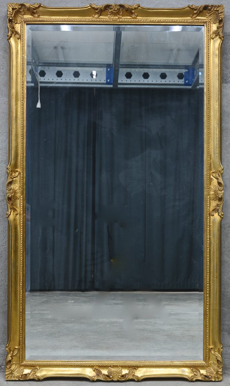 Een grote rechthoekige spiegel in verguld houten lijst.