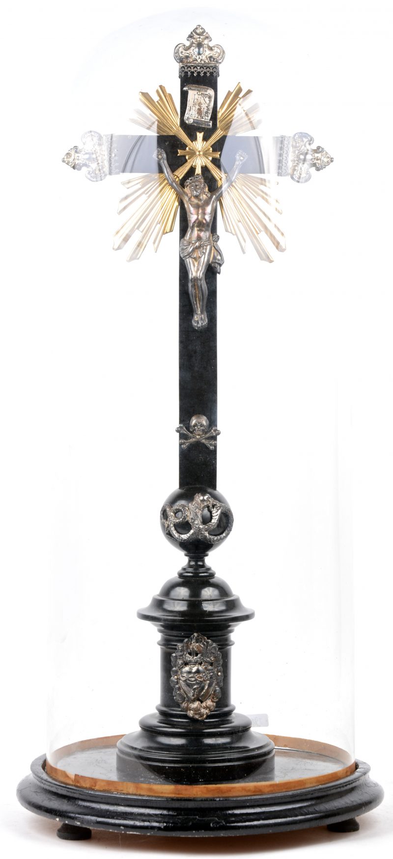 Een gedraaid houten kruisbeeld met zilveren corpus en monturen en onder stolp. De zilveren monturen tijdperk barok.
