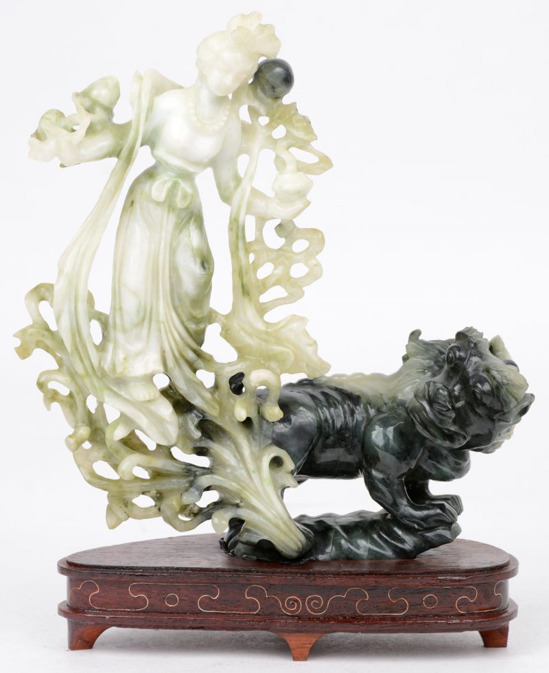 “Jonge vrouw met fabeldier”. Een beeld van gesculpteerd jade op een houten voetstuk. Peking.