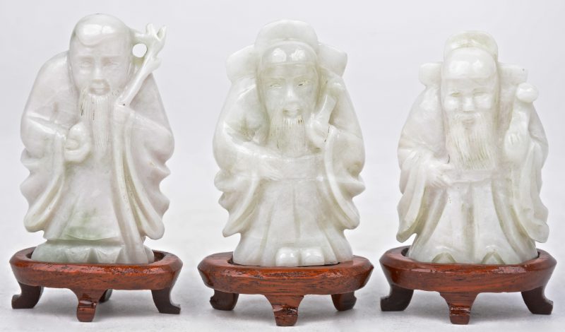 Drie oude Chinese wijzen van gesculpteerd witte jade. Met houten voetstukjes.