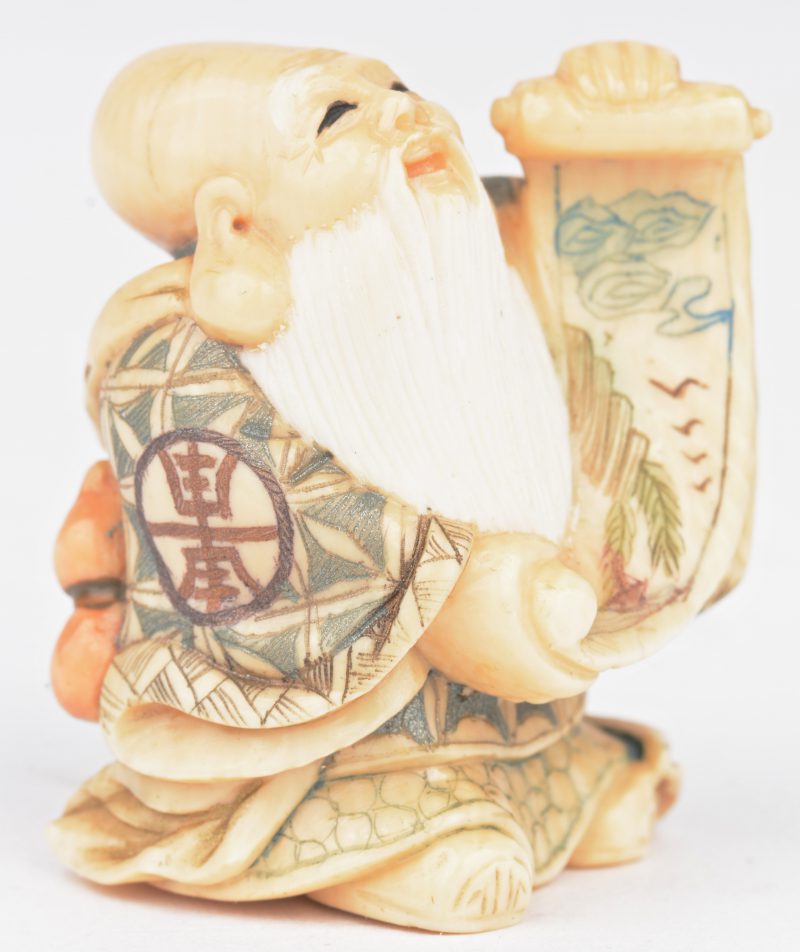“Fukurokuju met zijn scroll van wijsheid”. Een fijn gesculpteerde en gepolychromeerde mammoetivoren netsuke. Onderaan gesigneerd.