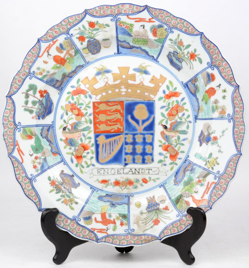 Een sierschotel van meerkleurig Chinees porselein, versierd met een fantasie-wapenschild in het plat in de geest van het Chine-de-commande.