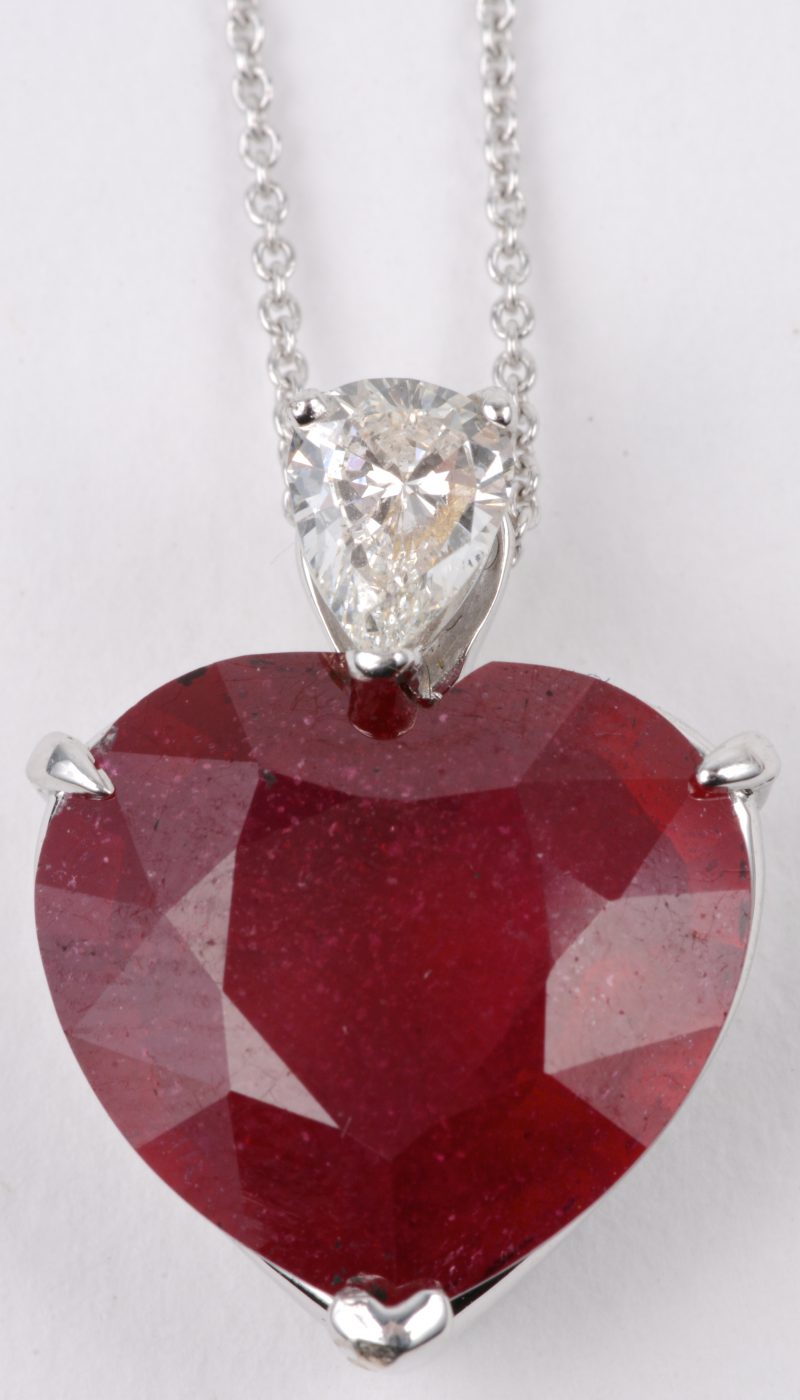 Een 18 karaats wit gouden ketting met hanger bezet met diamant van ± 0,30  ct. en een hartvormige robijn van ± 6,50 ct.