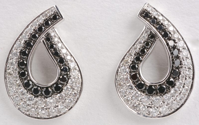 Een paar 18 karaats wit gouden oorbellen bezet met diamanten wit en zwart met een gezamenlijk gewicht van ± 1,08 ct.