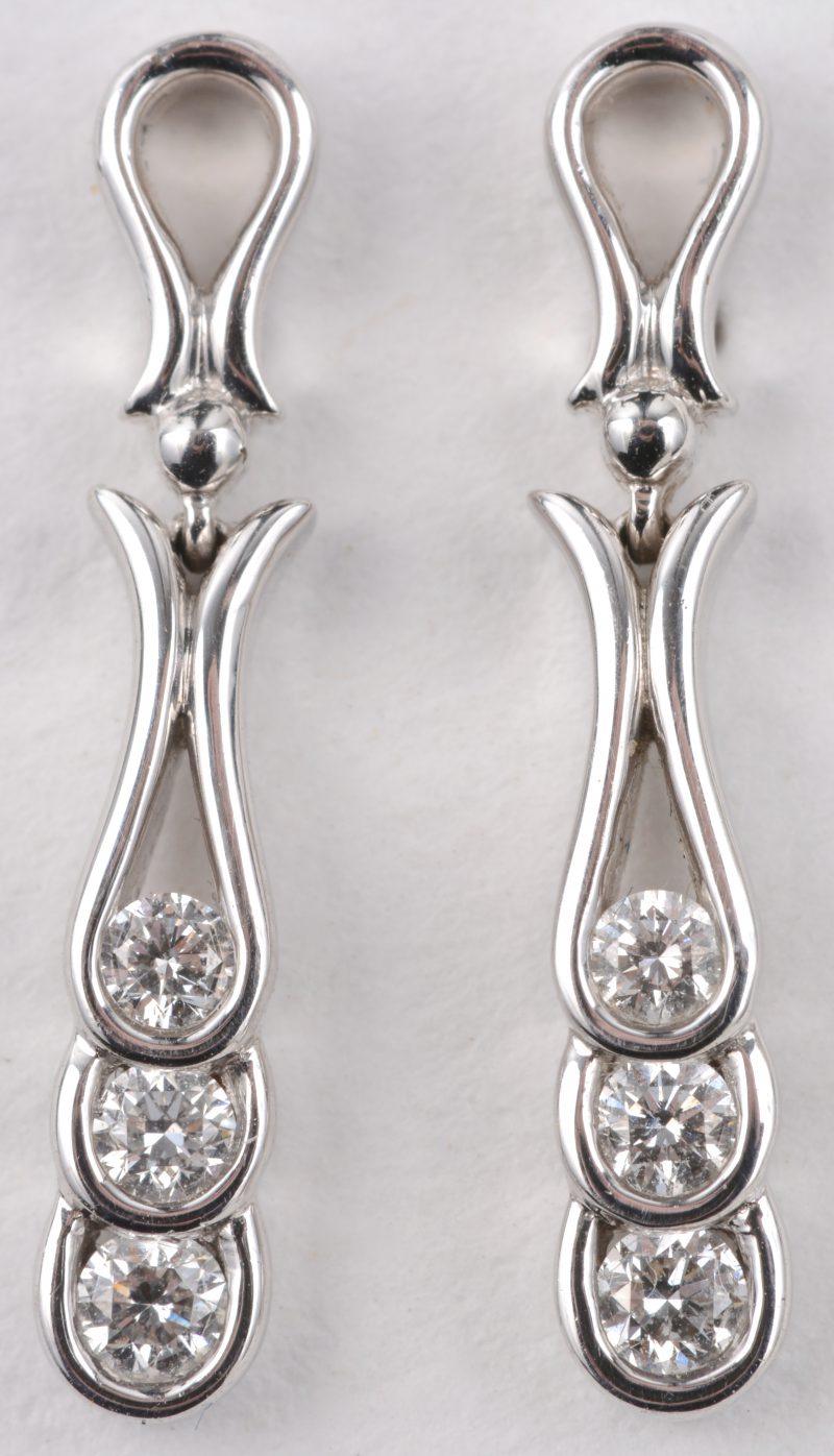 Een paar 18 karaats wit gouden oorbellen bezet met diamanten met een gezamenlijk gewicht van ± 0,26 ct.