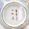 Een kraagvaasje van meerkleurig Japans porselein met een decor van personages in cartouches en pauwen in een landschap rondom. Onderaan gemerkt. Barst en schilfer aan de kraag. XIXe eeuw.