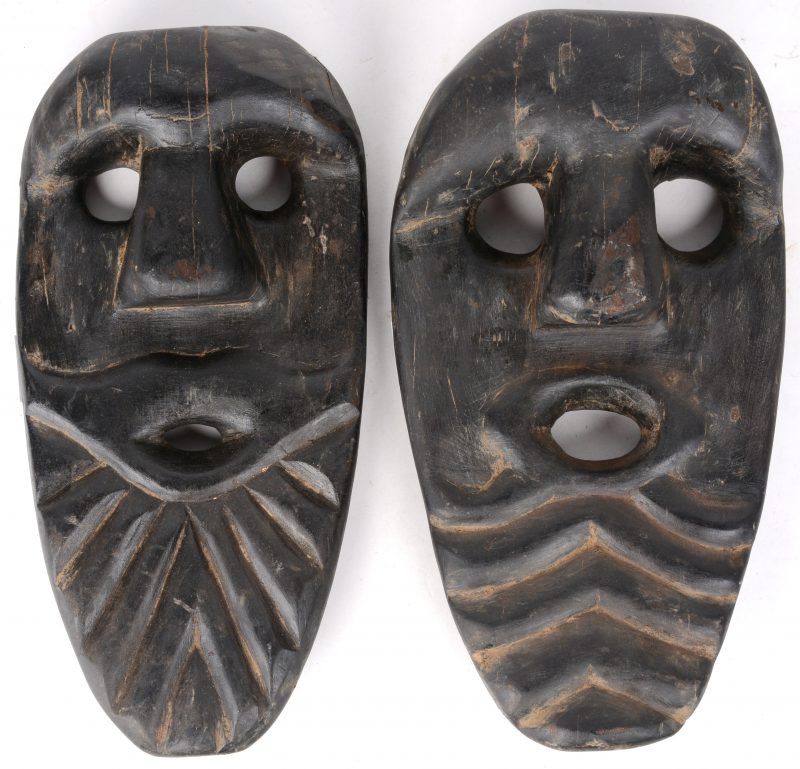 Twee Afrikaanse maskers van gebeeldhouwd ebbenhout.