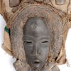 Een Afrikaans masker van gebeeldhouwd hout, voorzien van een sluier van jute en textiel.