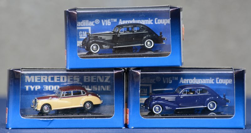Drie modelauto’s op schaal HO in originele dozen:- Cadillac V16 Aerodynamic Coupé 1934 zwart.- Cadillac V16 Aerodynamic Coupé 1934 blauw.- Mercedes-Benz Typ 300c Limousine 1955.