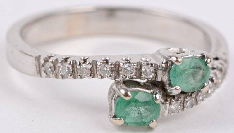 “Toi et Moi”. Een 18 karaats wit gouden ring bezet met diamantjes met een gezamenlijk gewicht van ± 0,12 ct. en smaragd met een gezamenlijk gewicht van ± 0,30 ct.