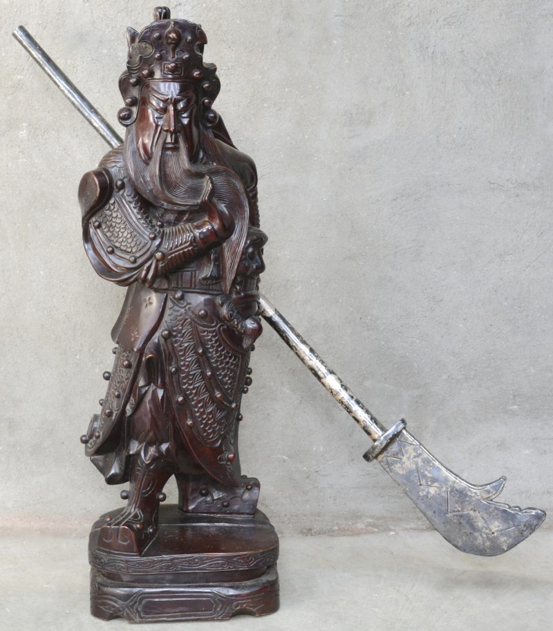 Een houten beeld van een Chinese krijger met gleve.