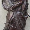 Een houten beeld van een Chinese krijger met gleve.