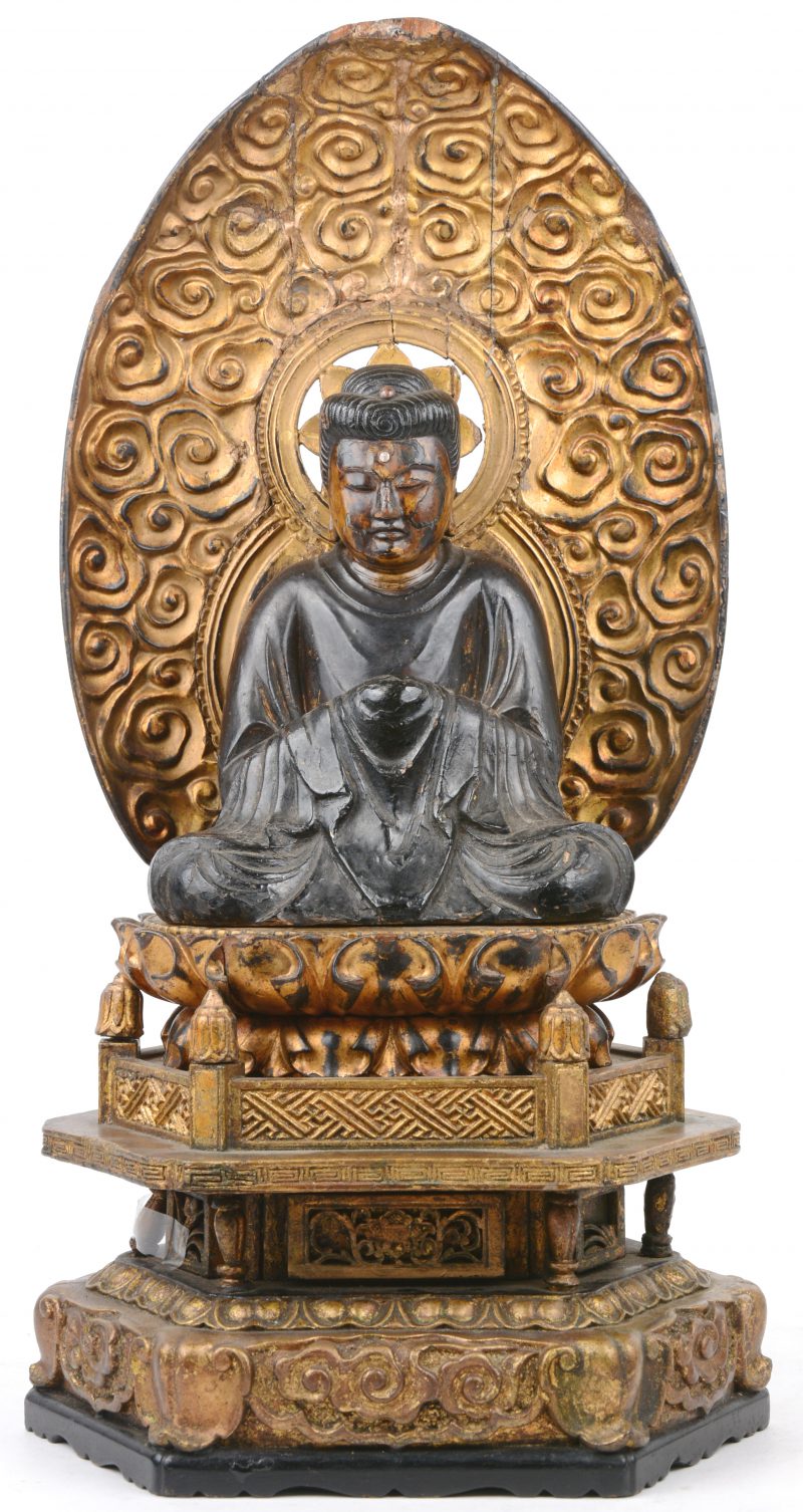 Een houten Japanse Boedha op een troon.